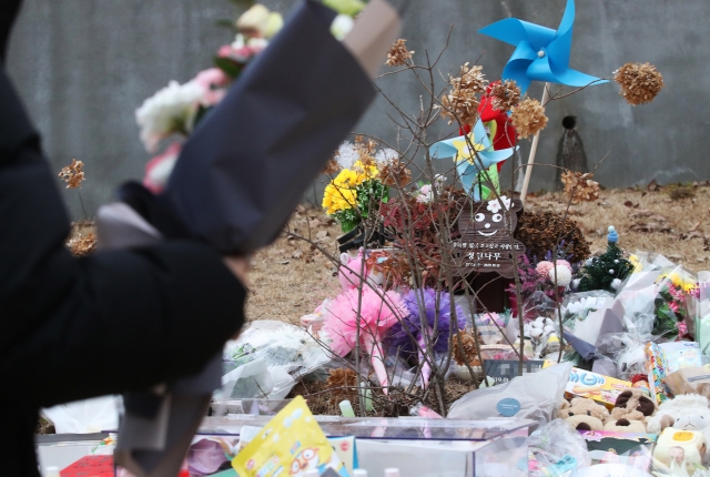 ▲양부모의 학대로 생후 16개월 만에 사망한 정인 양이 안치된 경기도 양평군 하이패밀리 안데르센 공원묘원에서 시민이 추모 꽃다발을 놓고 있다. (연합뉴스)