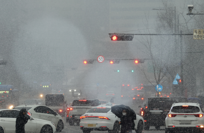 ▲서울 지역에 눈이 내리기 시작한 12일 오후 서울 중구 서울광장 인근 도로에서 차량들이 눈길을 오가고 있다. (연합뉴스)