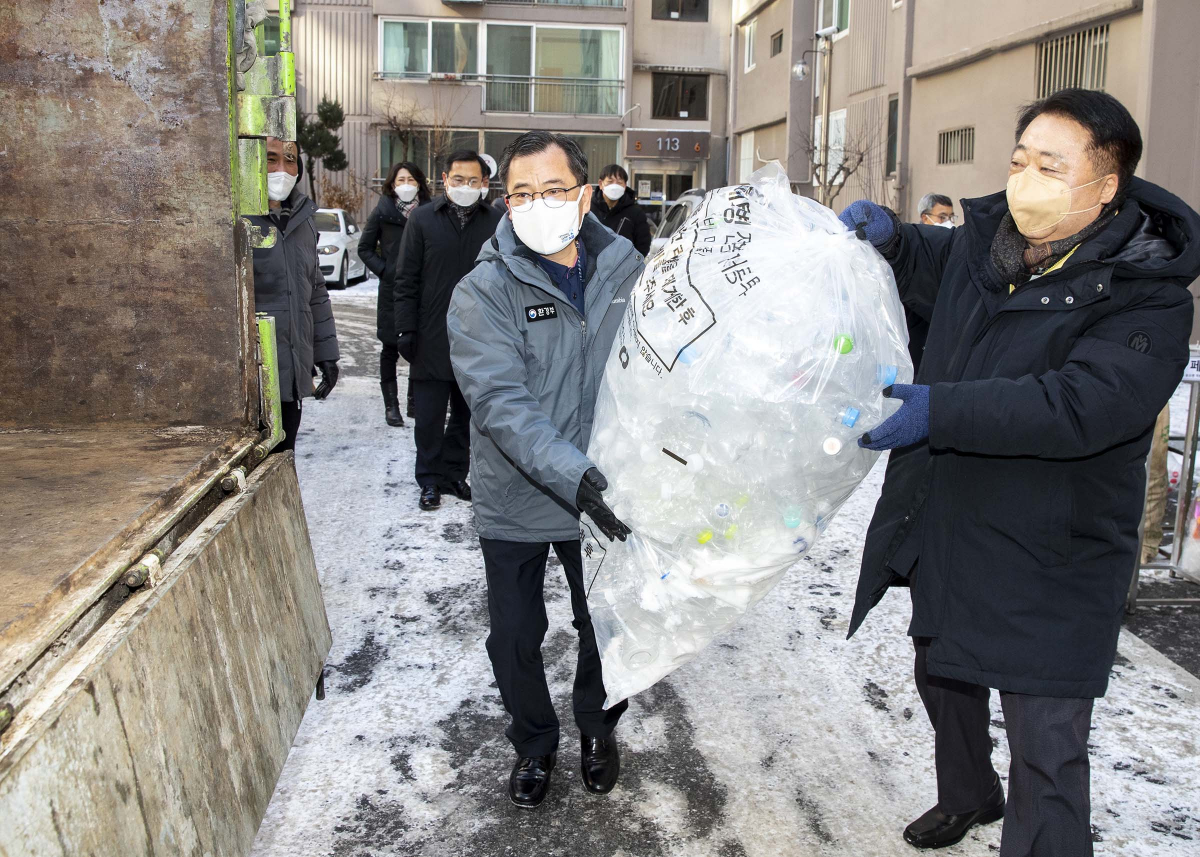 ▲홍정기(왼쪽) 환경부 차관이 한범덕 청주시장과 함께 8일 충북 청주시 소재 아파트를 방문해 별도 배출된 투명페트병을 전용 수거 차량에 싣고 있다. (뉴시스)