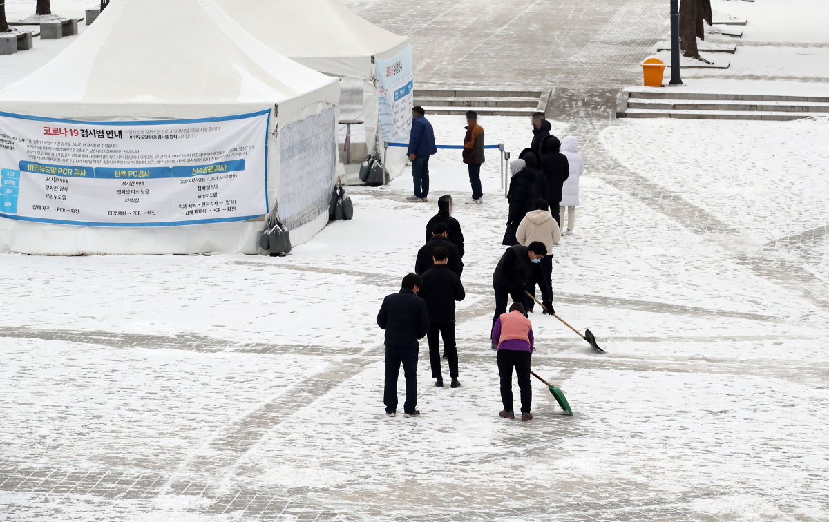 ▲눈이 내린 18일 오전 인천시 남동구 중앙공원 내 신종 코로나바이러스 감염증(코로나19) 임시선별검사소에서 관계자들이 검사를 받는 시민들을 위해 눈을 치우고 있다. (뉴시스)