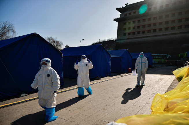 ▲중국 베이징에서 18일 방역복을 입은 의료진이 신종 코로나바이러스 감염증(코로나19) 검사소를 지나고 있다. 중국의 전날 신규 확진자 수는 109명으로 집계됐다. 베이징/로이터연합뉴스