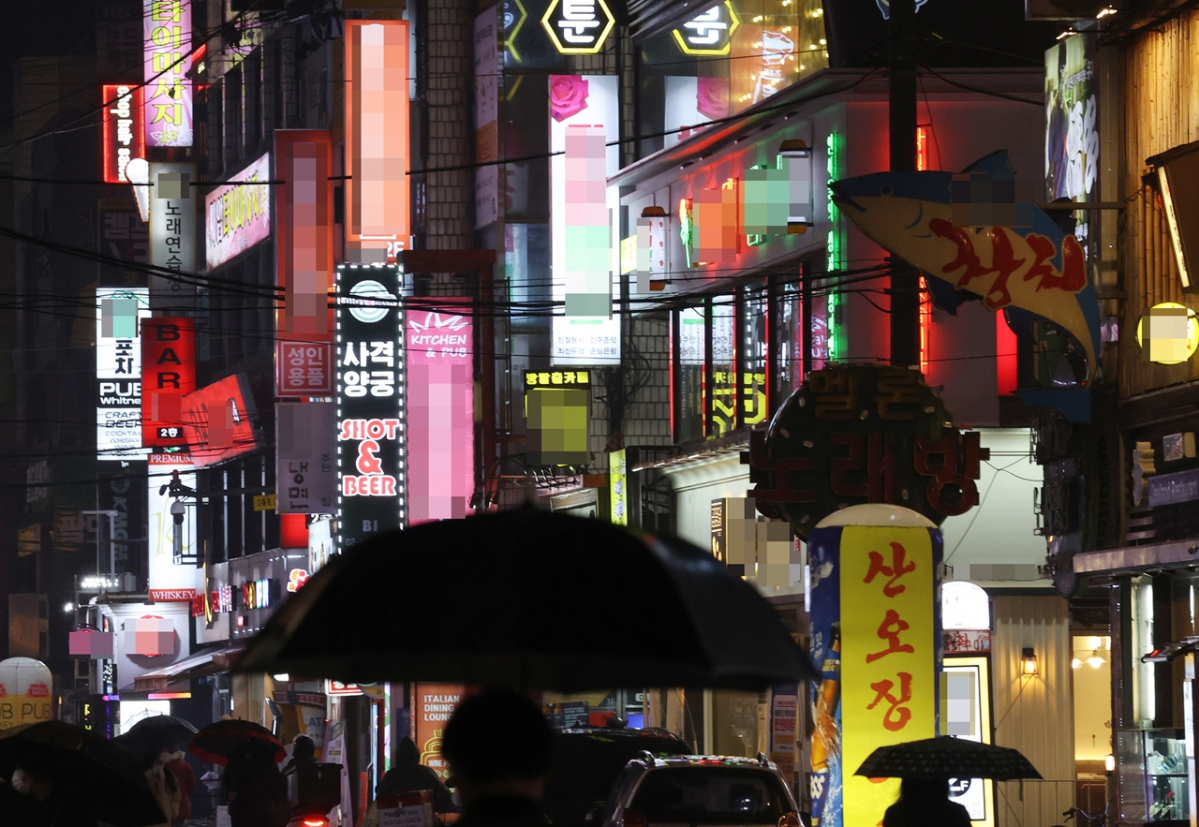 ▲21일 밤 유흥시설들이 들어선 서울 송파구 잠실새내역 인근 거리에 밤 9시가 넘어 간판 불을 밝힌 업소들 사이로 시민들이 귀가하고 있다. (연합뉴스)