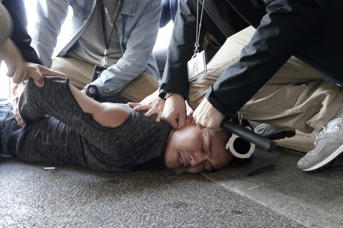 ▲2019년 12월 18일 홍콩 여객터미널에서 시위를 벌이던 한 민주화 운동가가 홍콩 경찰에 의해 제압되고 있다. 홍콩/AP뉴시스