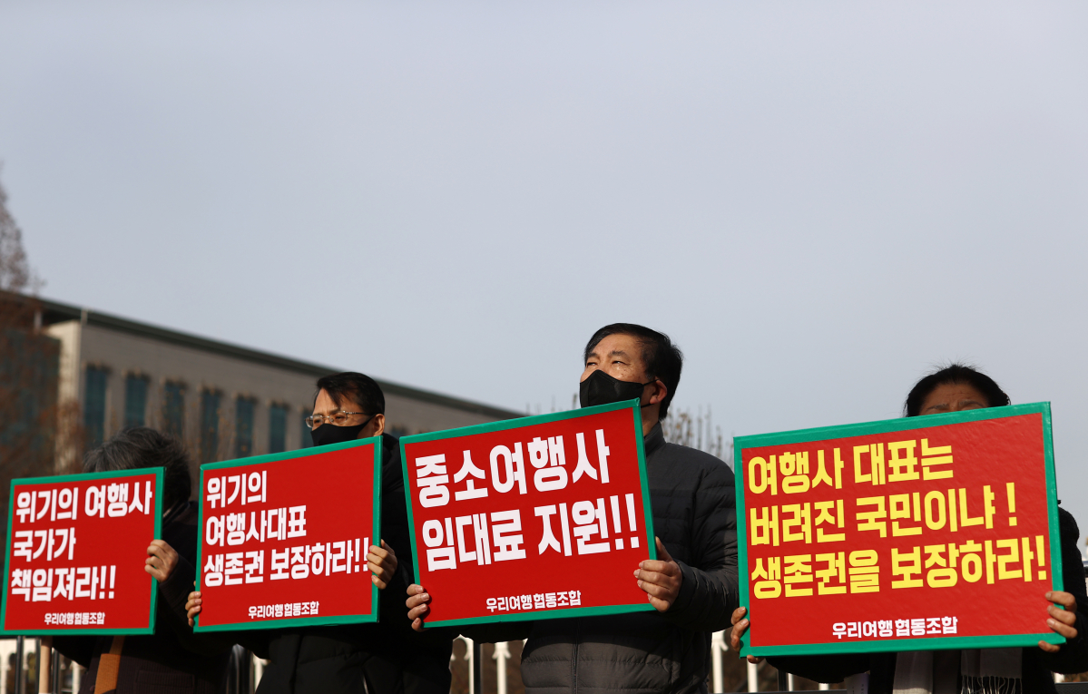 ▲25일 오전 서울 국회 앞에서 열린 '여행업계 생존권 보장을 위한 운영자금 지원 요청, 우리여행협동조합 입장 발표 기자회견'에서 참석자들이 관련 내용이 적힌 피켓을 들고 있다.  (연합뉴스)