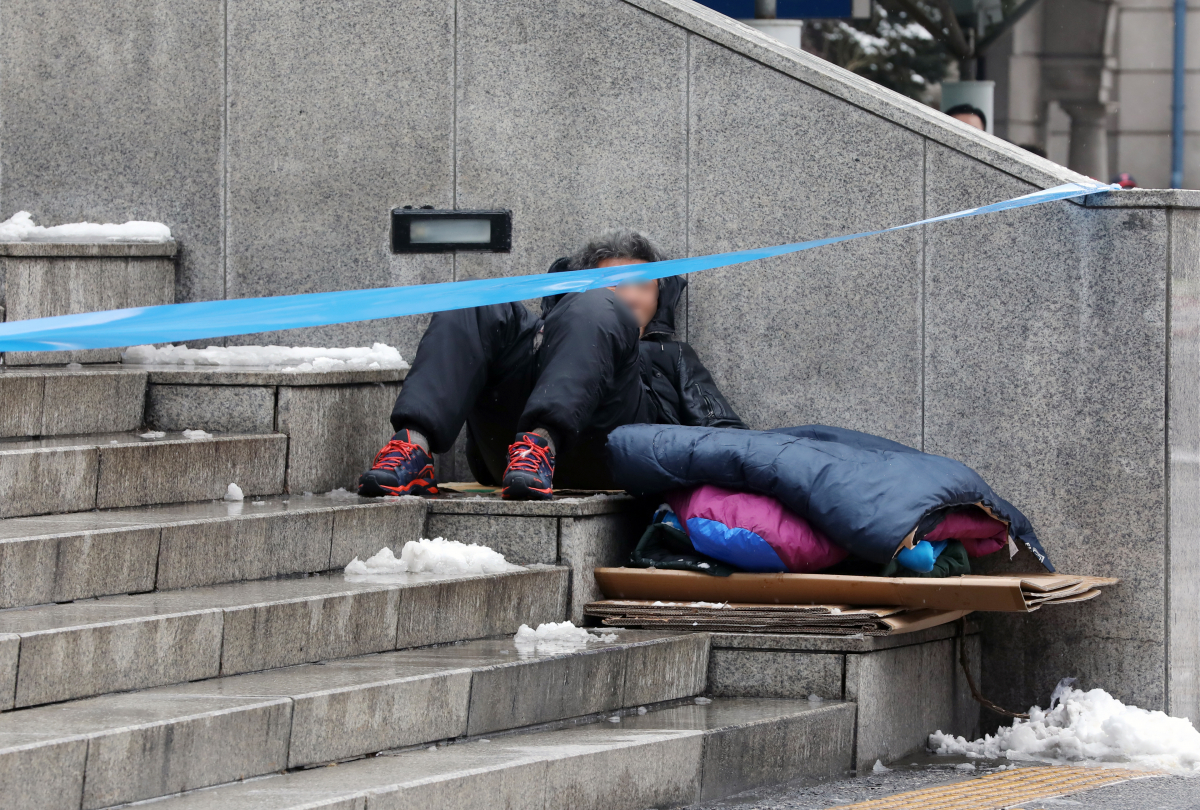 ▲노숙인이 28일 오전 서울 용산구 서울역광장에서 휴식을 취하고 있다. 신종 코로나바이러스 감염증(코로나19) 확진자가 발생한 서울역 희망지원센터는 지난 26일부터 운영이 중단되고 있다. (뉴시스)