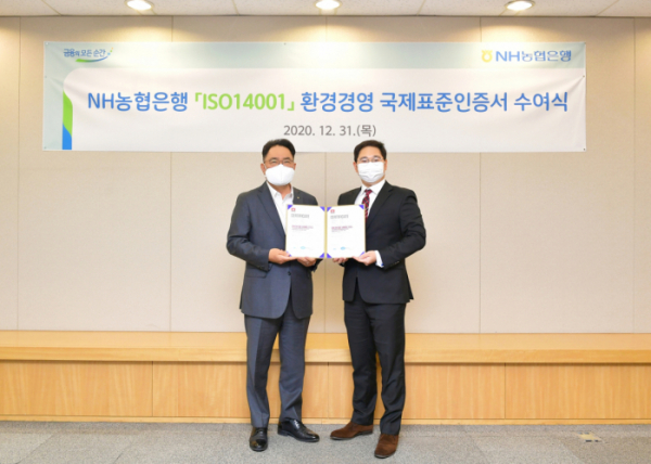 ▲지난 12월 31일 서울시 중구에 위치한 농협은행 본점에서 NH농협은행 지준섭 농업·녹색금융부문 부행장(왼쪽)과 로열서트코리아 이권상 대표(오른쪽)가 ISO 14001 인증서 수여식을 갖고 기념촬영을 하고 있다. (사진제공=NH농협은행)