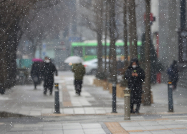 ▲서울에 눈이 내린 12일 오후 서울 광화문 거리에서 시민들이 우산을 쓰고 이동하고 있다. (연합뉴스)
