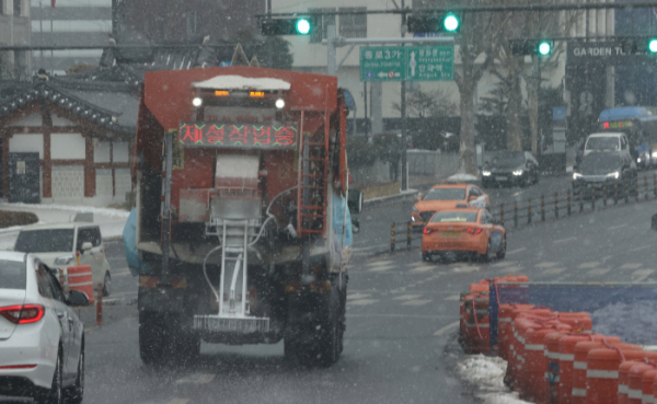 ▲서울 지역에 눈이 내리기 시작한 12일 오후 서울 종로구 일대 도로에서 제설작업차량이 염화칼슘을 살포하며 이동하고 있다.  (연합뉴스)