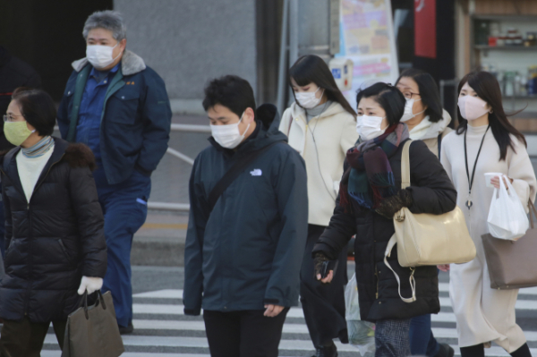 ▲일본 도쿄에서 13일 행인들이 신종 코로나바이러스 감염증(코로나19) 전염을 막기 위해 마스크를 착용하고 걷고 있다. 도쿄/AP뉴시스 