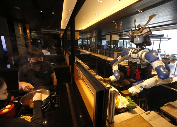 ▲태국 방콕의 한 일본 음식점에서 15일 로봇이 서빙하고 있다. 신종 코로나바이러스 감염증(코로나19) 사태에 로봇이 더 폭 넓게 쓰이고 있다. 방콕/EPA연합뉴스
