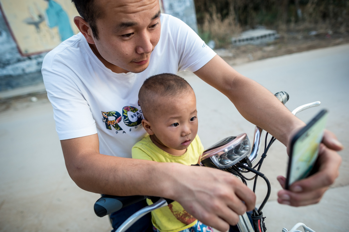 ▲3일(현지시간) 중국 인터넷 사용 인구가 10억 명에 육박했다는 통계 조사가 나왔다. 사진은 허베이성 싱타이에서 주민이 아들에게 스마트폰으로 온라인 쇼핑하는 모습을 보여주고 있는 모습. 싱타이/신화뉴시스
