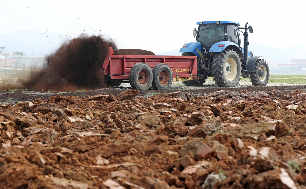 ▲퇴비를 뿌린 후 트랙터를 이용해 갈아 엎고 있는 밭. (뉴시스)