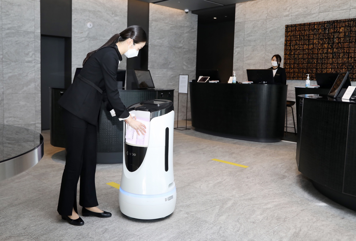 ▲롯데호텔 직원이 배달 요청된 호텔용품을 딜리버리 로봇에 넣는 모습. 로봇은 엘리베이터를 이용해 주문한 고객이 묵는 방 바로 앞까지 간다. (사진제공=호텔롯데)