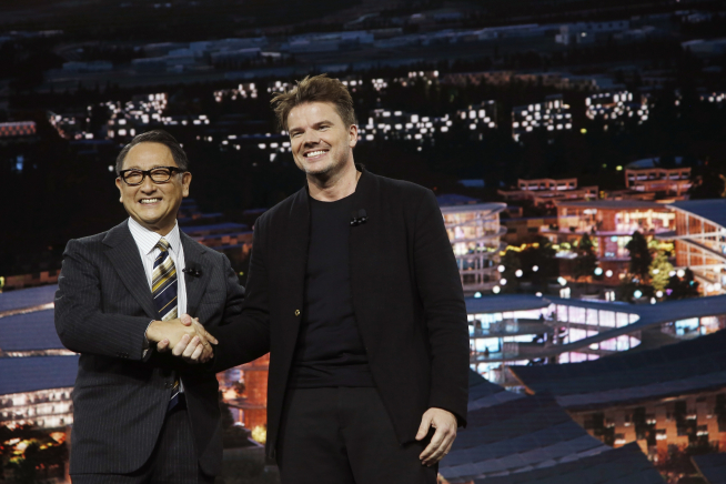 ▲도요다 아키오(왼쪽) 도요타 사장과 비야케 잉겔스 건축가가 지난해 1월 6일 미국 라스베이거스에서 열린 'CES 2020'에서 스마트시티 '우븐시티' 계획을 공개하며 악수하고 있다. 라스베이거스/AP뉴시스