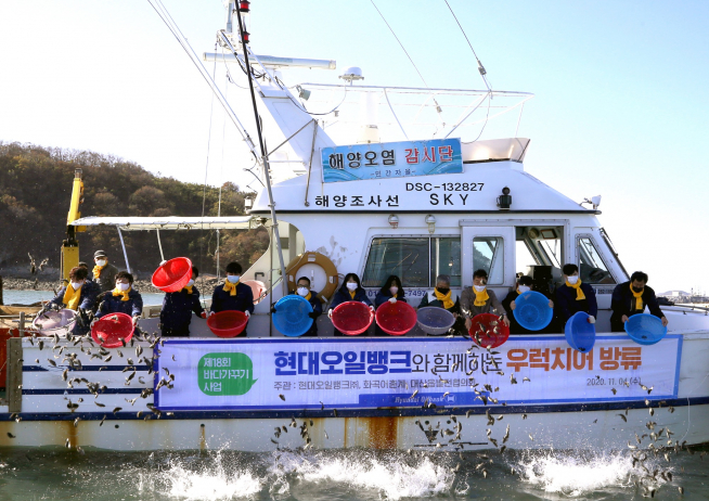 ▲현대오일뱅크, 화곡어촌계, 대산읍발전협의회가 지난해 11월 제18회 바다가꾸기 사업을 열고 우럭 치어를 방류하고 있다. (사진=현대오일뱅크)