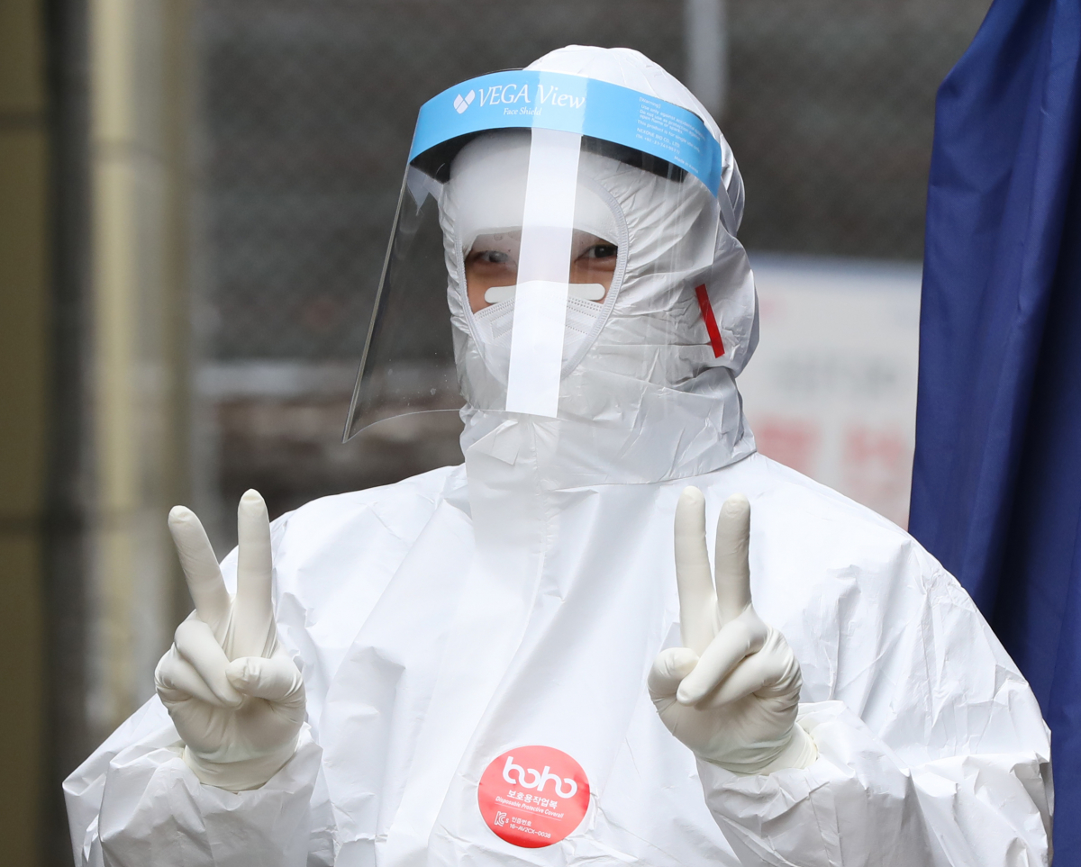 ▲서울 송파구 보건소 코로나19 선별진료소에서 한 의료인이 손가락으로 'V(브이)'를 만들어보이고 있다. (뉴시스)