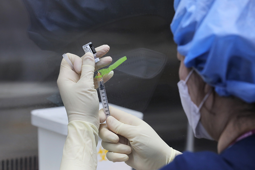 ▲코로나19 환자 치료 의료진을 대상으로 한 화이자 백신 접종이 시작된 27일 오전 서울시 중구 국립중앙읭료원 중앙예방접종센터 내 무균 작업대(클린벤치)에서 의료진이 화이자 백신을 주사기에 소분 조제하고 있다.  (사진공동취재단)