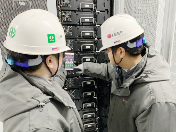 ▲LG전자 직원들이 전남 신안군 안좌스마트팜앤쏠라시티에 구축한 에너지저장장치(ESS; Energy Storage System)의 동작상황을 스마트폰을 통해 확인하고 있다. (사진제공=LG전자)