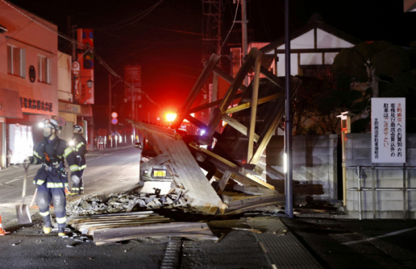 ▲13일 밤 일본 후쿠시마현 앞바다에서 발생한 규모 7.3의 강진이 발생한 가운데 14일 새벽 후쿠시마 쿠리 소방당국이 무너진 주택 문을 수습하고 있다. 쿠리/로이터연합뉴스  