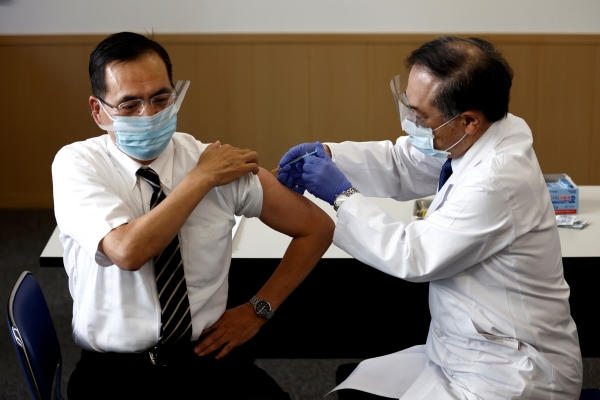 ▲도쿄 메구로(目黑)구에 소재한 도쿄의료센터의 아라키 가즈히로 원장(왼쪽)이 17일 일본 최초로 신종 코로나바이러스 감염증(코로나19) 백신을 접종받고 있다. 도쿄/로이터연합뉴스
