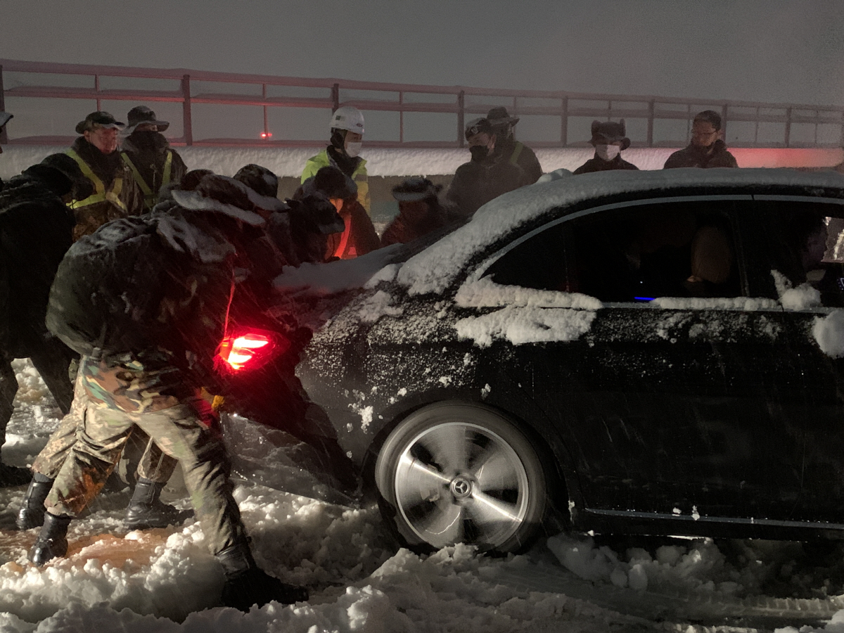 ▲동해고속도로 폭설 고립 차량 구출에 나선 육군 8군단과 102기갑여단 장병들이 2일 노학2교 부근에서 눈길에 빠진 차량을 밀고 있다.
(자료=연합뉴스)