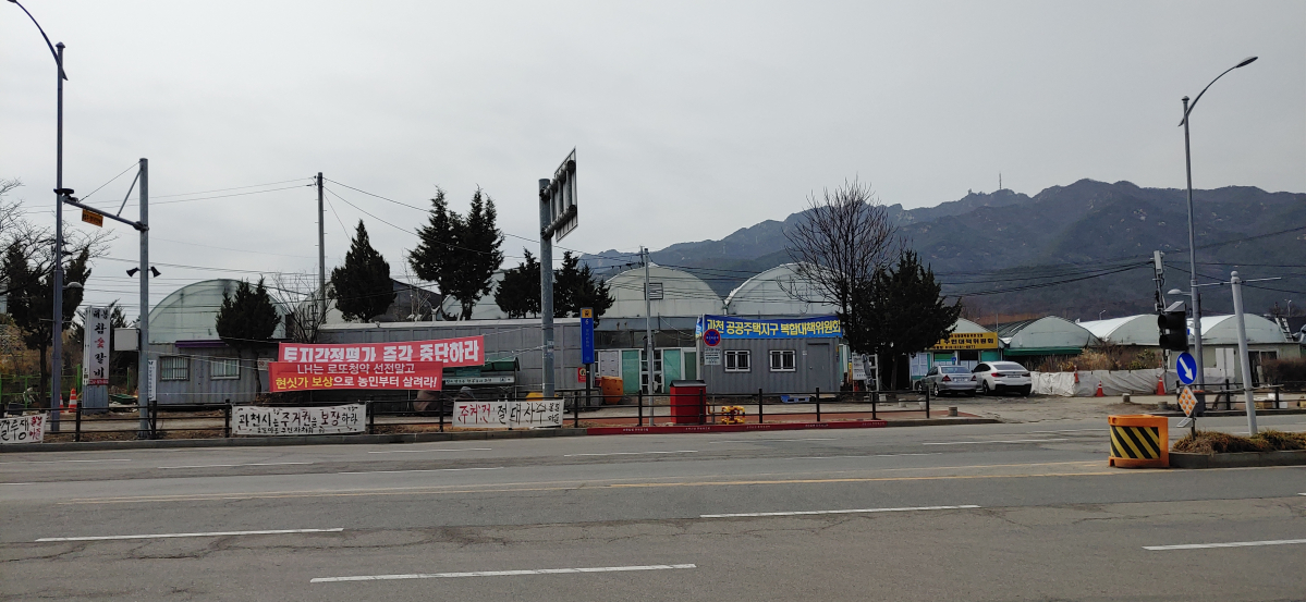 ▲경기도 과천시 경마공원역 주변에 토지수용에 반대하는 현수막들이 내걸려 있다. 옆으로는 주민대책위원회 컨테이너가 들어섰다.