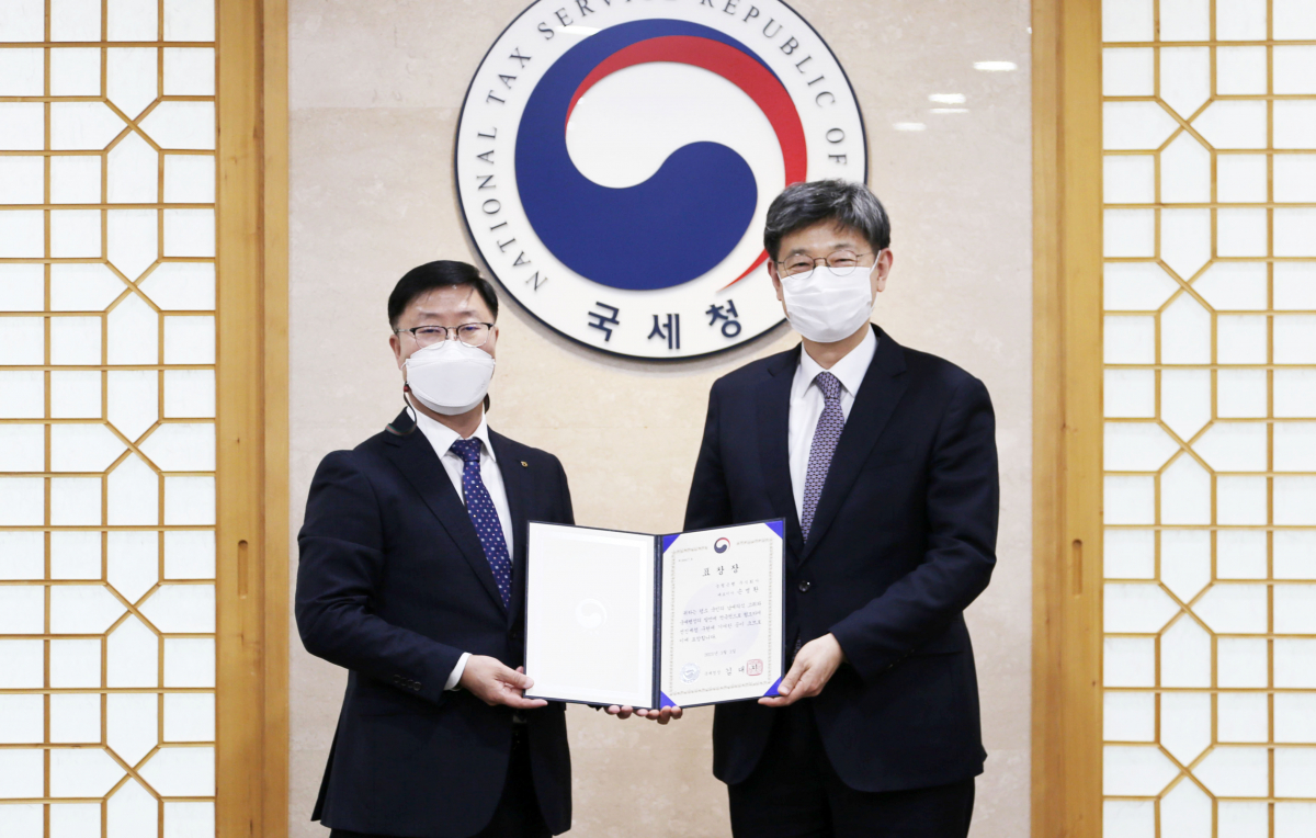 ▲김동일(오른쪽) 국제조세관리관과 남재원 농협은행 부행장이 표창장을 들고 기념촬영을 하고 있다. (사진제공= 농협은행)