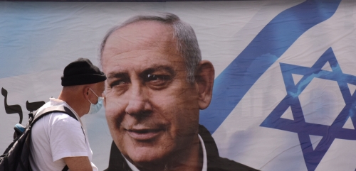 ▲21일(현지시간) 한 남성이 베냐민 네타냐후 이스라엘 총리 포스터 앞을 지나가고 있다. 예루살렘/UPI연합뉴스
