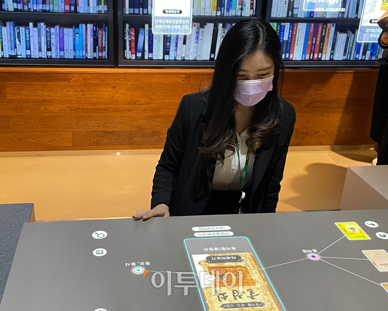 ▲22일 서울 서초구 국립중앙도서관 디지털도서관 내 실감콘텐츠 체험관인 '실감서재'에서 관계자가 디지털 터치스크린으로 책을 검색하는 '검색의 미래' 코너를 시연하고 있다. (김소희 기자 ksh@)