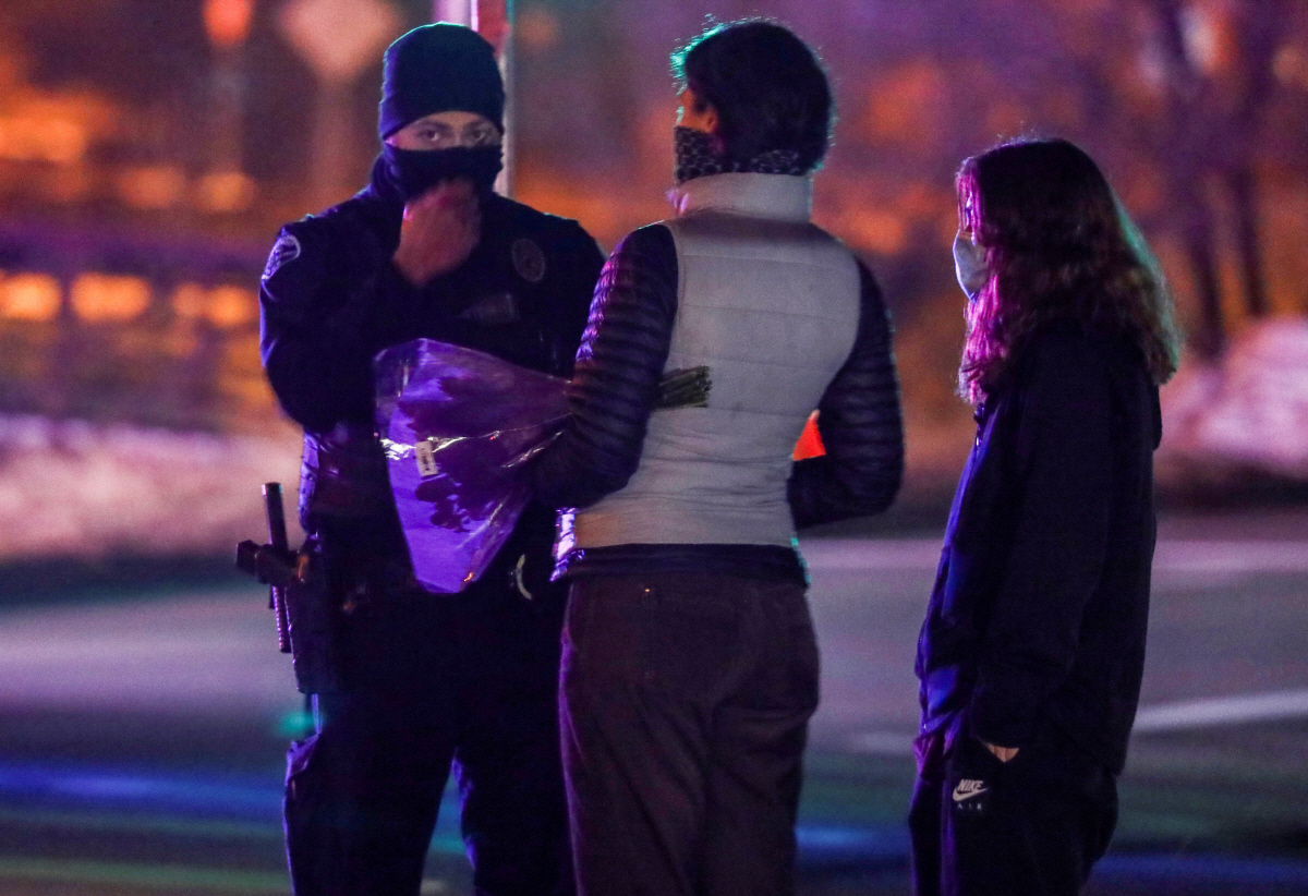 ▲미국 콜로라도주 볼더에서 22일(현지시간) 총기 난사 사건이 발생한 가운데 현장 인근에서 주민이 애도하기 위해 꽃을 들고 있다. 볼더/로이터연합뉴스 
