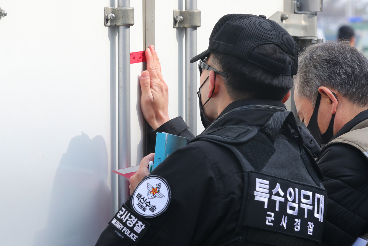 ▲미국 제약사 화이자 코로나19 백신 50만회분(25만명분)이 국내에 반입된 24일 오전 인천국제공항 화물터미널에서 백신을 실은 수송차량에 군 관계자가 봉인지를 붙이고 있다. (뉴시스)