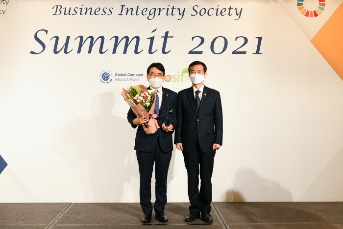 ▲한국무역보험공사 윤종배 본부장(왼쪽)이 26일 UNGC 한국협회와 한국사회책임투자포럼이 서울 종로 포시즌스호텔에서 진행한 ‘2021 반부패 써밋’에서 ‘반부패 어워드’를 수상하고 이건리 국민권익위원회 부위원장과 기념 촬영을 하고 있다. (사진제공=한국무역보험공사)