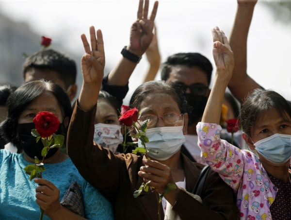 ▲1일 미얀마 양곤에서 쿠데타에 항의하는 시위대가 한 손에 꽃을 든 채 저항을 상징하는 세 손가락 경례를 하고 있다. 양곤/EPA연합뉴스
