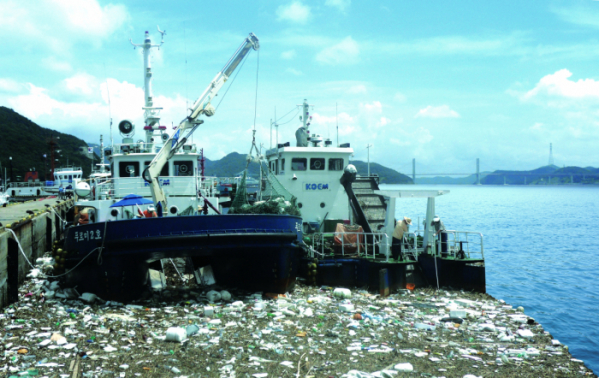 ▲해양환경공단이 2011년 9호 태풍 무이파로 마산항에 쌓인 해양쓰레기를 수거하고 있다. (사진제공=해양수산부)
