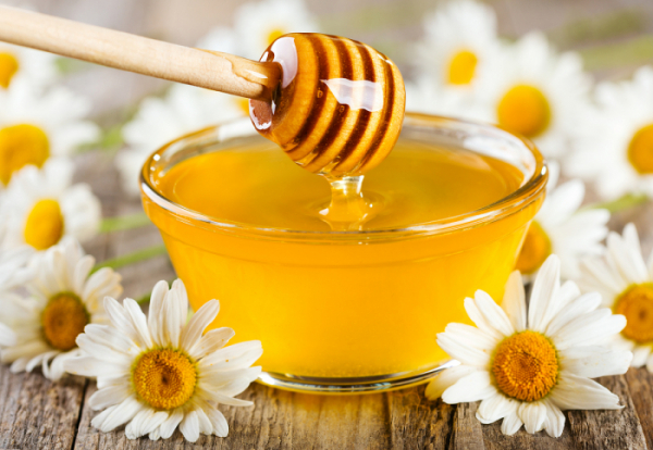 ▲pouring honey from wooden stick into bowl