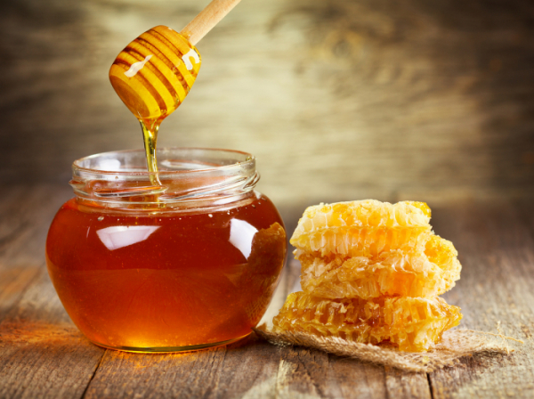 ▲jar of honey with honeycomb on wooden table