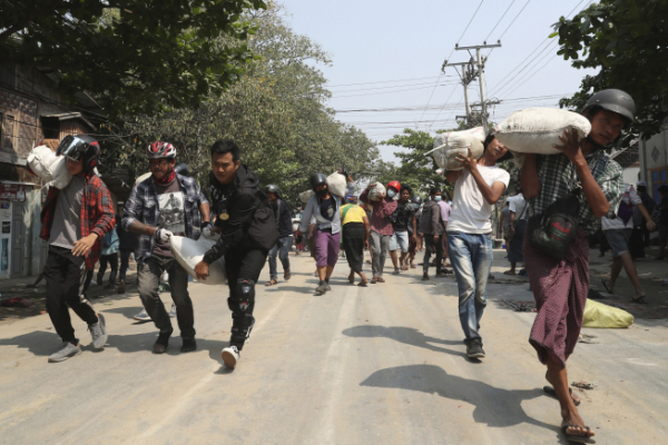▲미얀마 만달레이에서 13일(현지시간) 반쿠데타 시위대가 방어선을 구축하기 위해 모래주머니를 옮기고 있다. 만달레이/AP연합뉴스