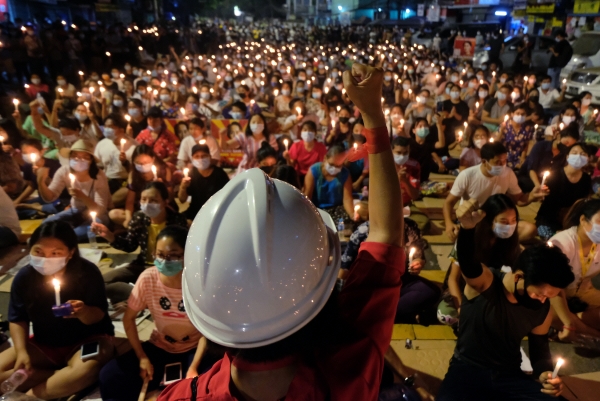 ▲14일(현지시간) 미얀마 양곤에서 열린 군부 쿠데타 반대 촛불집회가 열린 가운데 한 시위 참가자가 군중 앞에서 주먹을 들고 있다. 양곤/AP뉴시스
