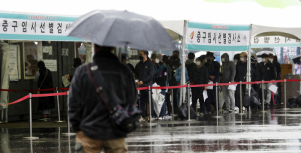 ▲코로나19 신규 확진자가 452명으로 집계된 20일 서울역 광장에 마련된 중구 임시 선별검사소에서 시민들이 우산을 쓰고 검사를 받기 위해 줄지어 기다리고 있다. (뉴시스)