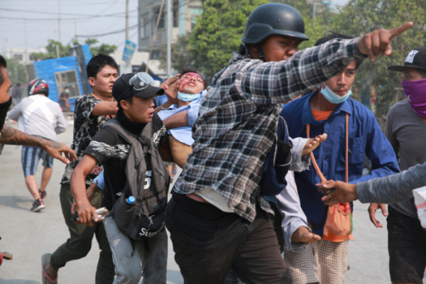 ▲미얀마 만달레이에서 시위대가 22일(현지시간) 부상 당한 동료 일원을 옮기고 있다. 만달레이/AP뉴시스