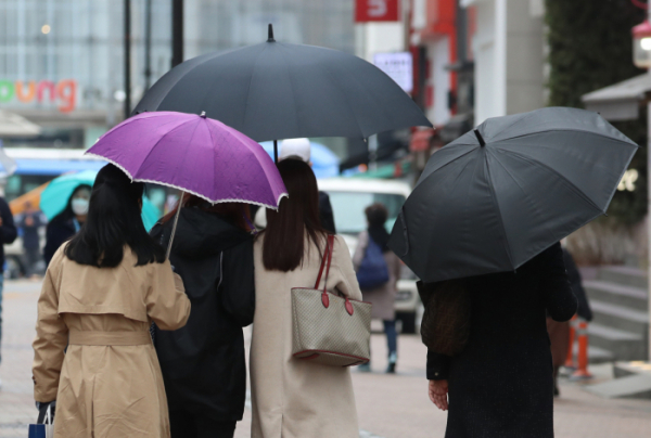 ▲전국에 봄비가 내리기 시작한 지난달 12일 서울 명동 거리에서 시민이 우산을 쓰고 있다.  (뉴시스)