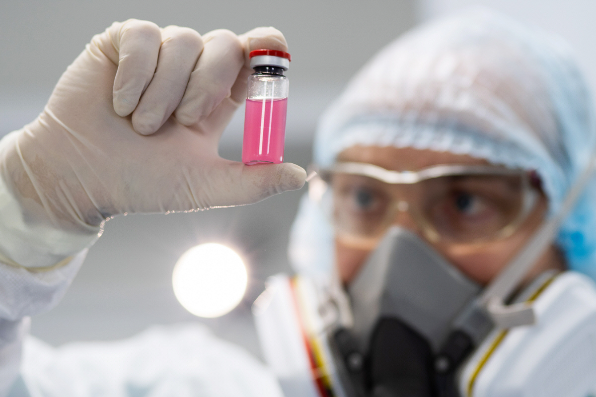 ▲한 사람이 러시아 연방 수의·식물감독청 산하 연방동물건강보호센터 실험실에서 동물용 코로나19 백신 '카르니박-코프(Carnivak-Cov)'가 담긴 유리병을 들고 있다. 타스연합뉴스