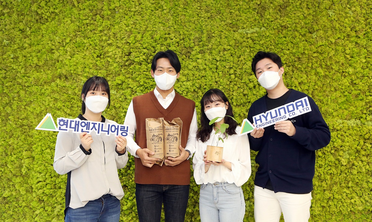 ▲'집에서 씨앗 키우는 통나무'에 참여한 현대엔지니어링 직원들이 도토리 씨앗이 들어있는 나무화분을 들고 기념촬영을 하고 있다. (사진제공=현대엔지니어링)