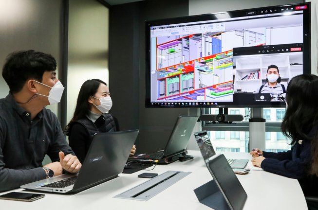 ▲DL이앤씨 직원들이 현장 직원과 BIM 설계 도면을 보면서 화상 회의를 하고 있다. (자료제공=DL이앤씨)