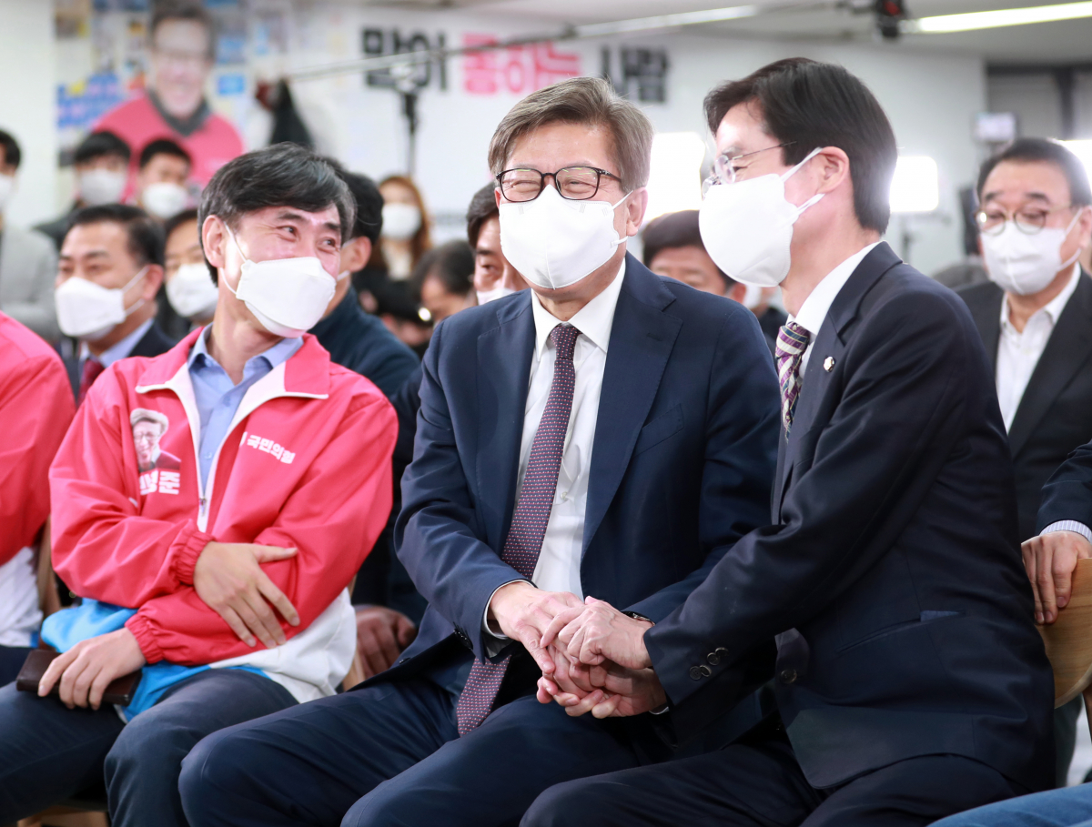 ▲박형준 국민의힘 부산시장 후보가 7일 오후 부산 부산진구 박형준 후보 선거캠프에서 출구조사 결과를 보며 조경태 의원과 악수하고 있다. (뉴시스)