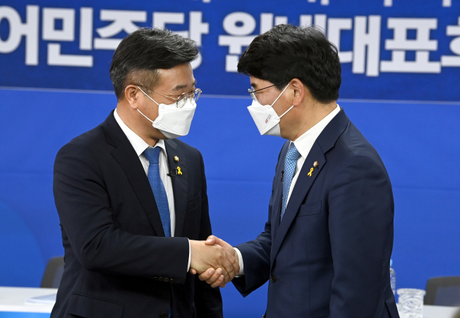 ▲더불어민주당 원내대표 경선에 출마한 윤호중 의원(왼쪽)과 박완주 의원이 15일 서울 여의도 중앙당사에서 열린 합동토론회에서 악수하고 있다.   (연합뉴스)