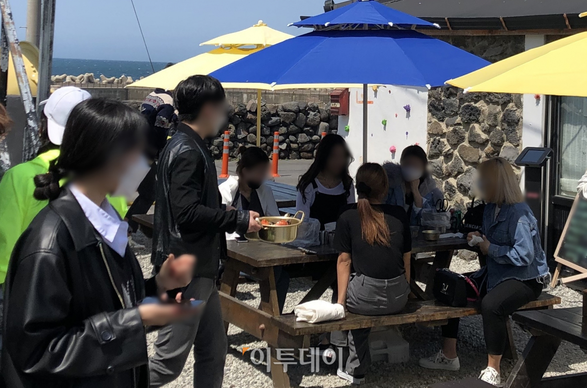 ▲11일 제주시에 있는 한 음식점에서 5명이 파라솔 아래 모여 앉아 식사를 기다리고 있다. (홍인석 기자 mystic@)