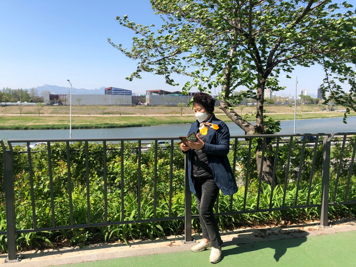 ▲14일 송정제방길에서 만난 김미 씨가 까치온으로 동영상을 보고 있다.  (홍인석 기자 mystic@)