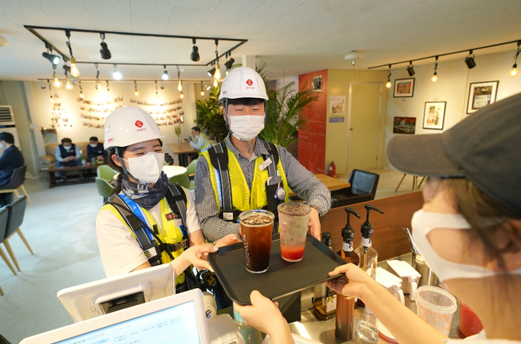 ▲롯데건설 직원들이 서울 강동구 아파트 건설현장 내에서 자사가 마련한 장애인 바리스타 카페를 이용하고 있다. (사진 제공=롯데건설)