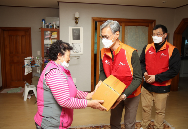 ▲조경목 SK에너지 대표이사(가운데)가 '한끼 나눔 온(溫)택트' 활동의 일환으로 도시락을 전달하고 있다. (사진제공=SK에너지)